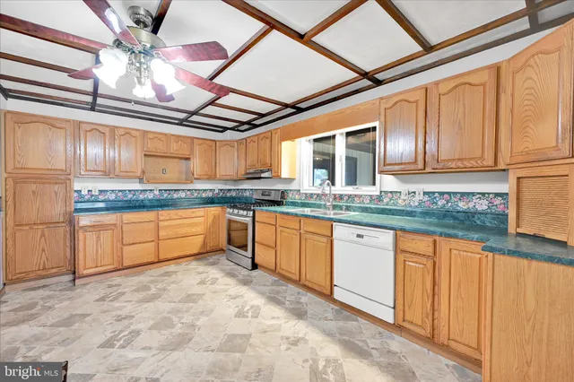 a large kitchen with granite countertop a sink and cabinets