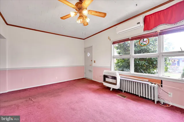 an empty room with a window and a ceiling fan