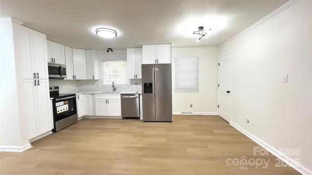 a kitchen with stainless steel appliances a refrigerator sink and cabinets
