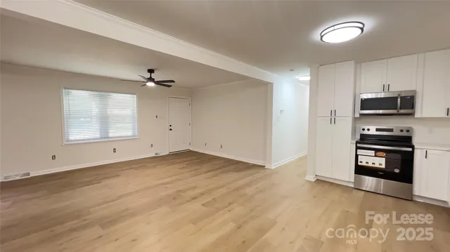 wooden floor in an empty room with a kitchen