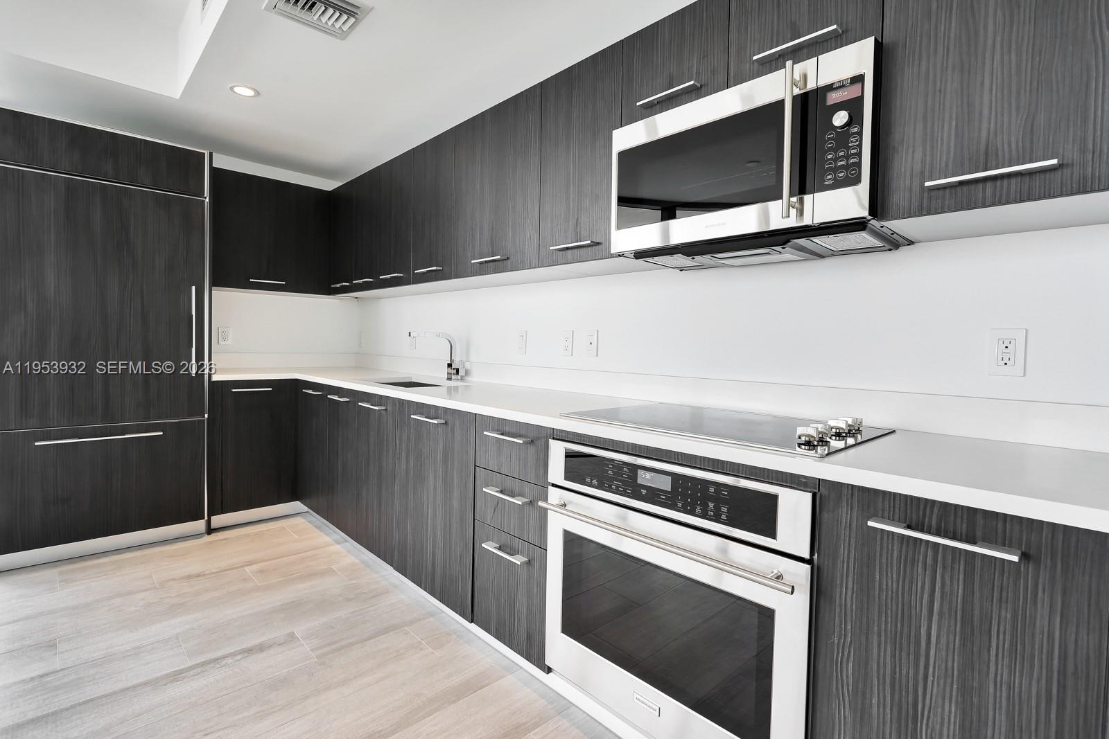 45 Southwest 9th Street, Unit 1806 Miami, FL 33130 - Photo 16 of 61 a kitchen with a sink stove and microwave