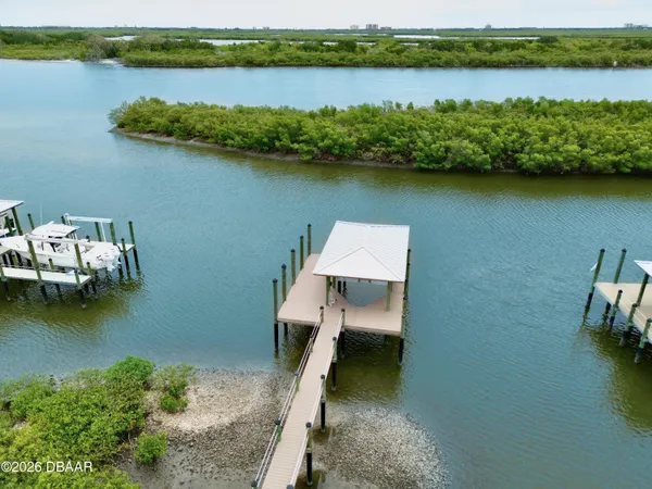 an aerial view of a residential house with outdoor space and lake view
