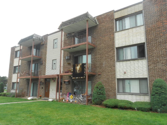 a front view of a residential apartment building with a yard
