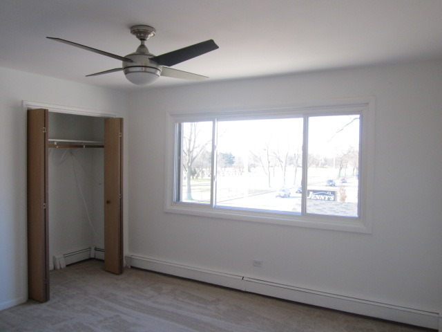 5724 West 111th Street, Unit 3B Chicago Ridge, IL 60415 - Photo 8 of 14 a view of an empty room with a window and a ceiling fan