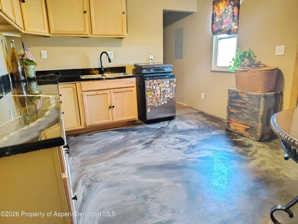 a kitchen with granite countertop a sink a stove and cabinets