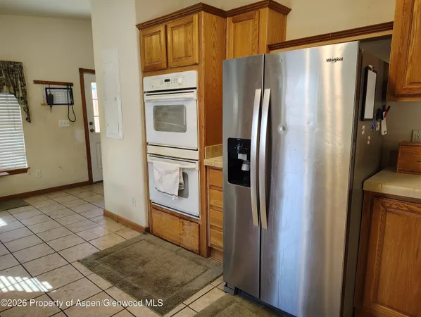 a metallic refrigerator freezer sitting in a kitchen