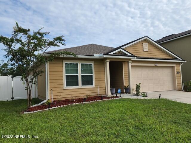4295 Packer Meadow Way Middleburg, FL 32068 - Photo 2 of 26 a front view of a house with a yard and garage