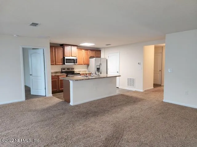 a kitchen with stainless steel appliances granite countertop a stove top oven a sink and dishwasher