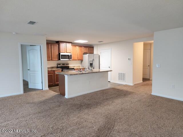 4295 Packer Meadow Way Middleburg, FL 32068 - Photo 4 of 26 a kitchen with stainless steel appliances granite countertop a stove top oven a sink and dishwasher