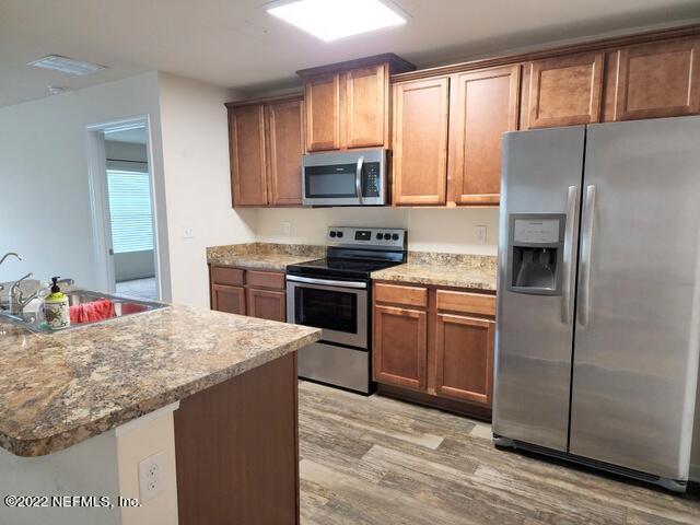 4295 Packer Meadow Way Middleburg, FL 32068 - Photo 5 of 26 a kitchen with granite countertop a refrigerator stove top oven and sink
