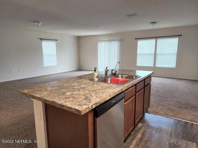 a bathroom with a granite countertop sink and a window