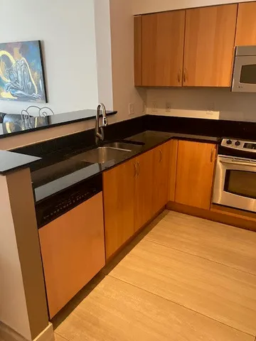 a kitchen with granite countertop cabinets and black stainless steel appliances