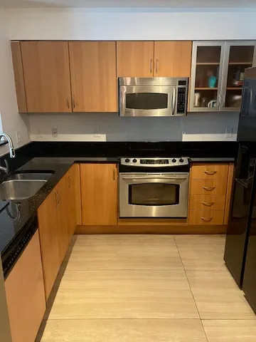 a kitchen with stainless steel appliances granite countertop a stove and a sink