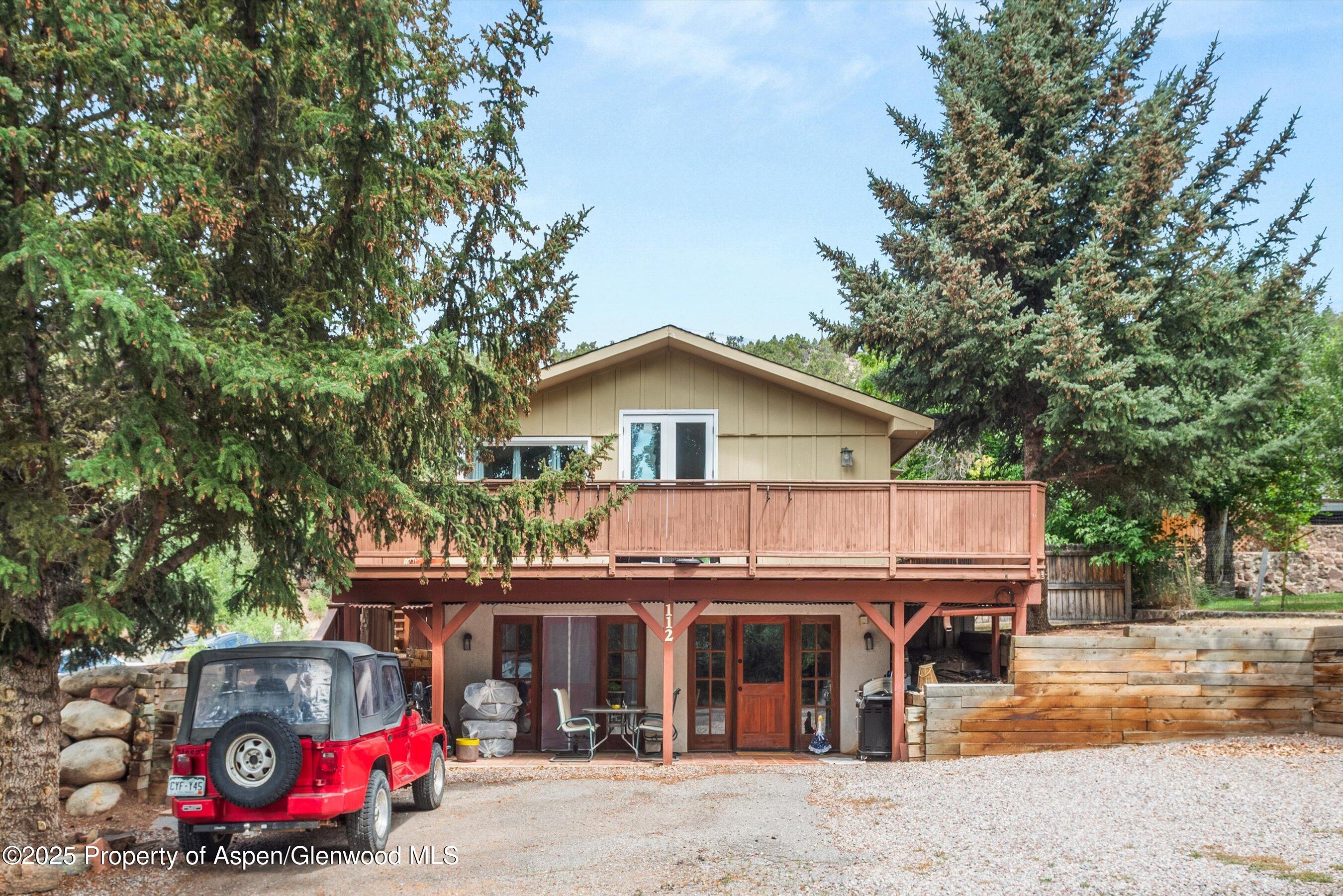 112 Hillside Drive Basalt, CO 81621 - Photo 1 of 28 a front view of house with outdoor seating and trees in the background