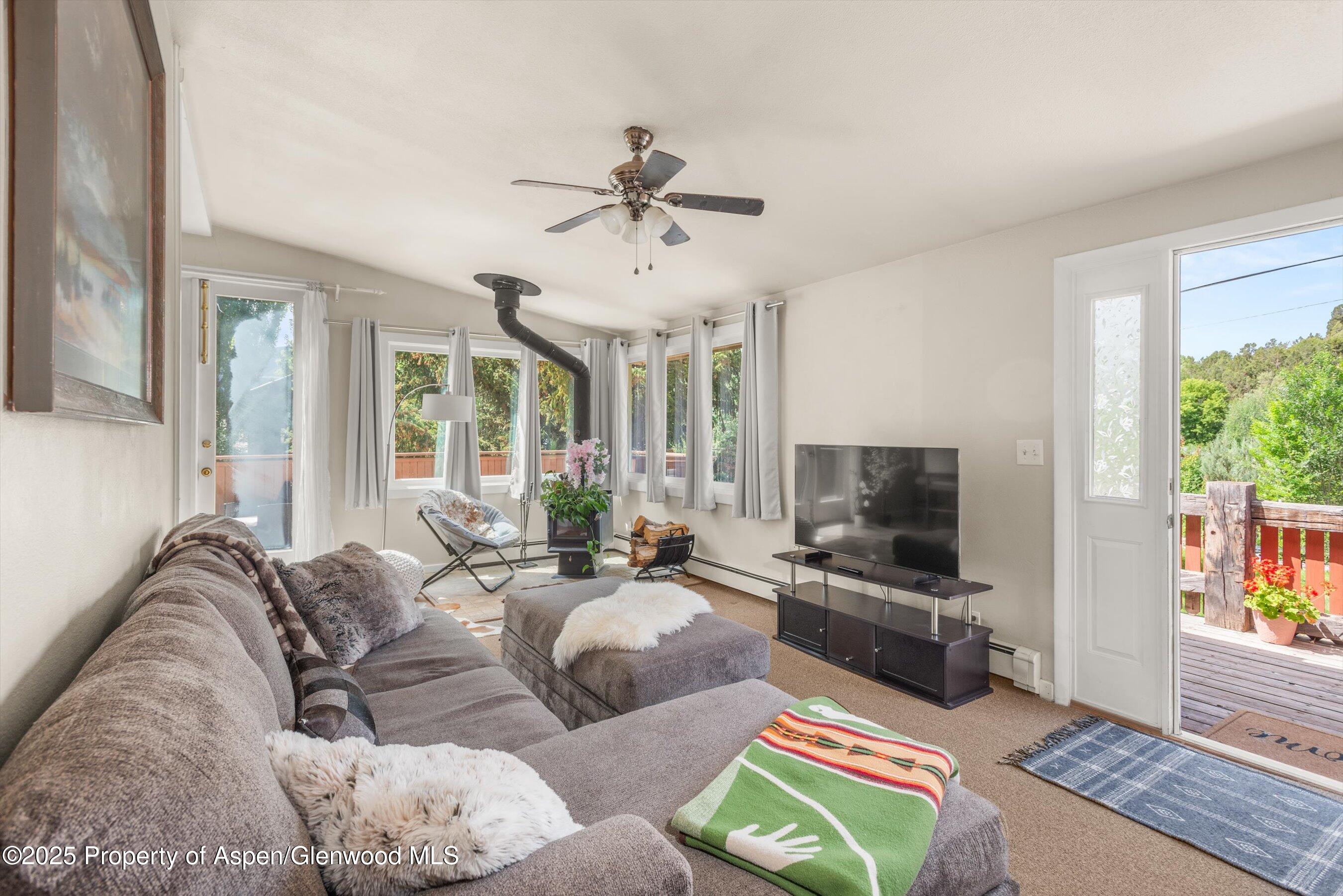112 Hillside Drive Basalt, CO 81621 - Photo 2 of 28 a living room with furniture a flat screen tv and a floor to ceiling window