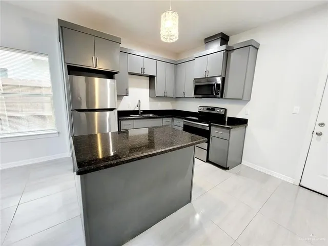 a kitchen with stainless steel appliances granite countertop a stove a sink and a refrigerator