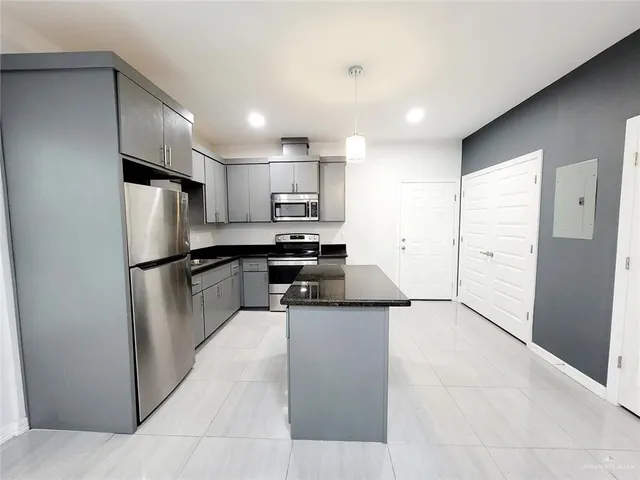 a kitchen with stainless steel appliances granite countertop a refrigerator stove a sink and a refrigerator