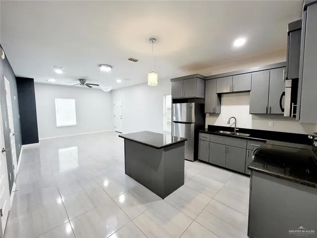 a kitchen with stainless steel appliances granite countertop a refrigerator and a stove