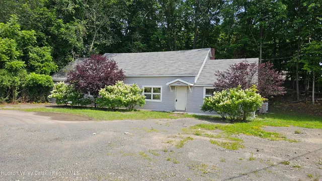 front view of a house with a yard and potted plants