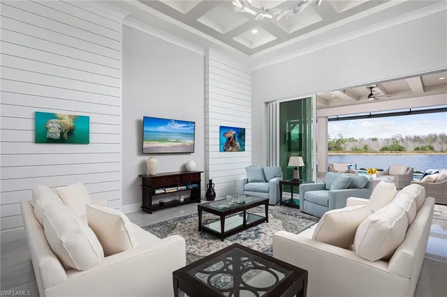 a living room with furniture a flat screen tv and a large window