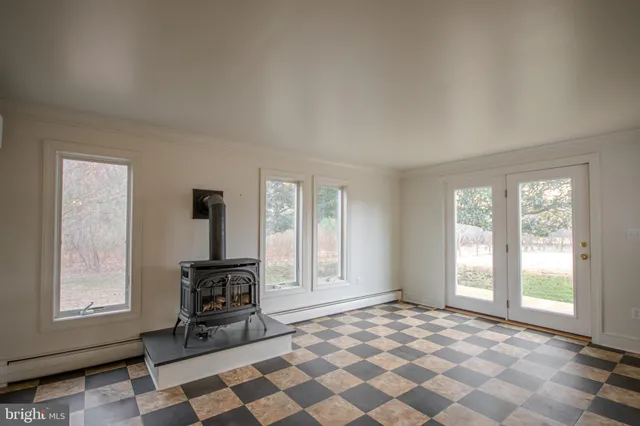 a view of an empty room with window and furniture