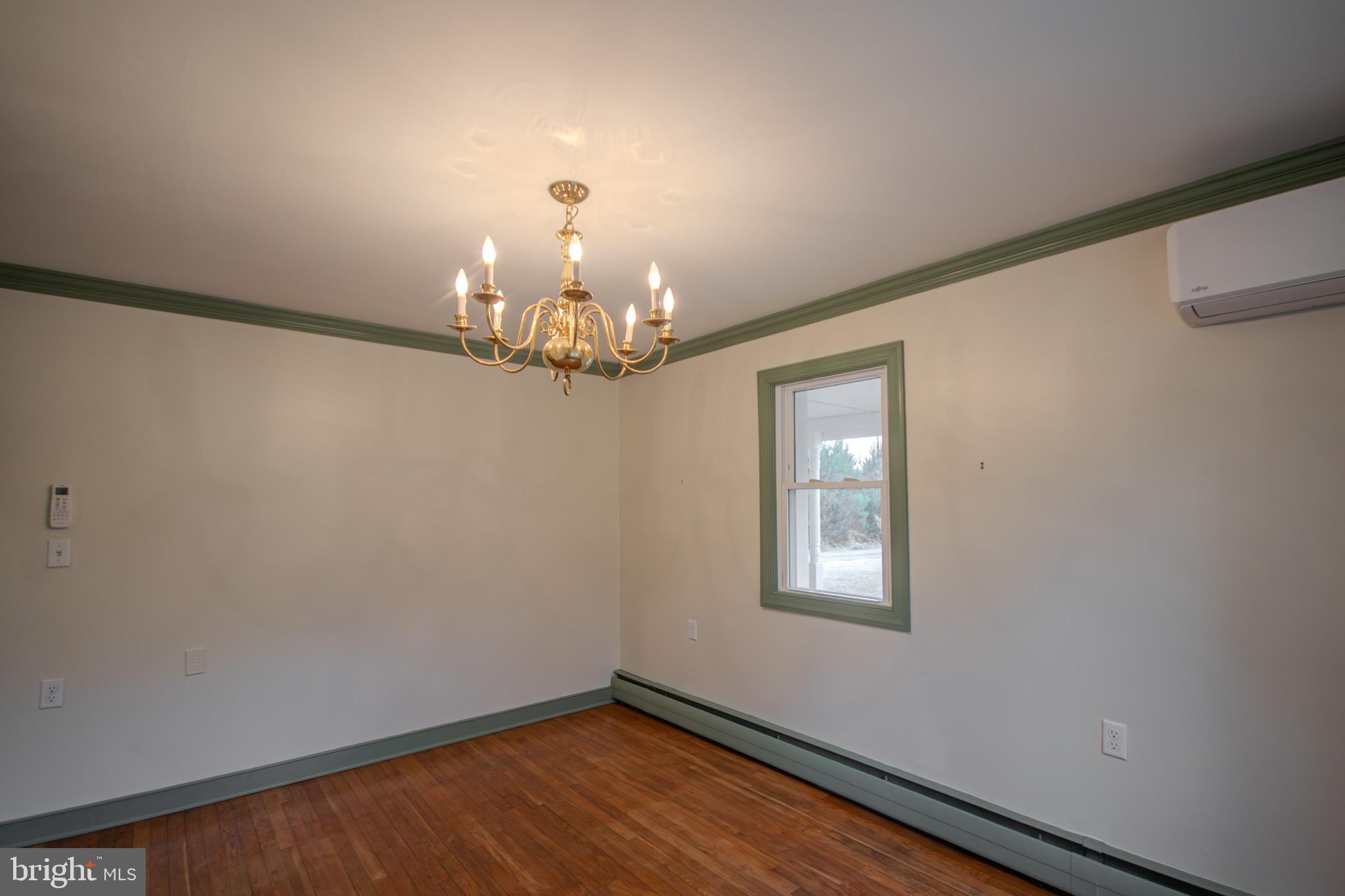 6817 Quantico Road Hebron, MD 21830 - Photo 16 of 39 a view of a hallway with wooden floor and chandelier