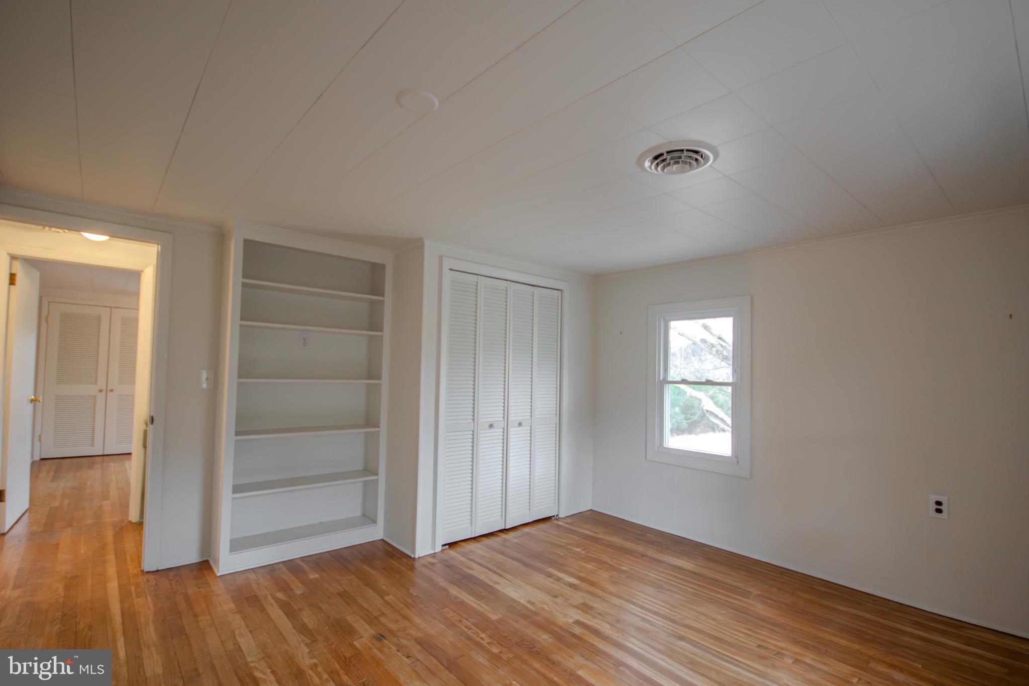 6817 Quantico Road Hebron, MD 21830 - Photo 20 of 39 an empty room with wooden floor closet and windows