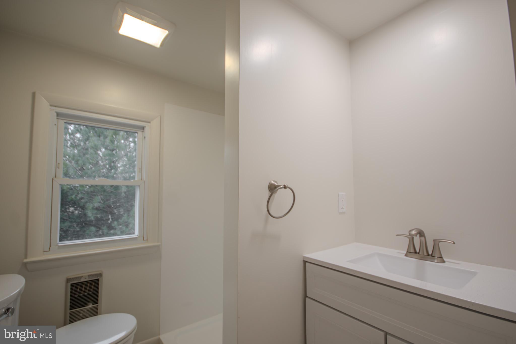 6817 Quantico Road Hebron, MD 21830 - Photo 22 of 39 a bathroom with a toilet sink vanity shower and mirror