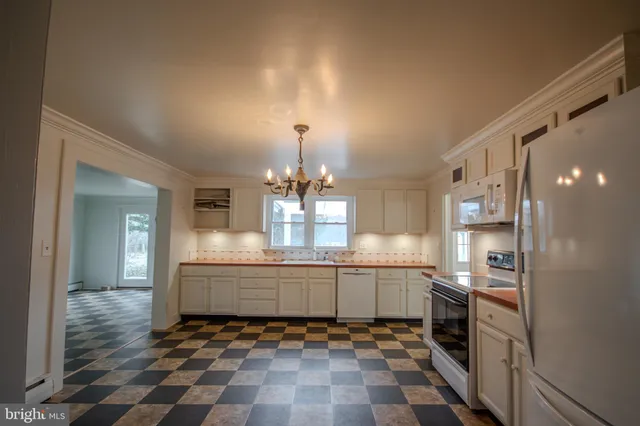 a large kitchen with granite countertop a sink and cabinets