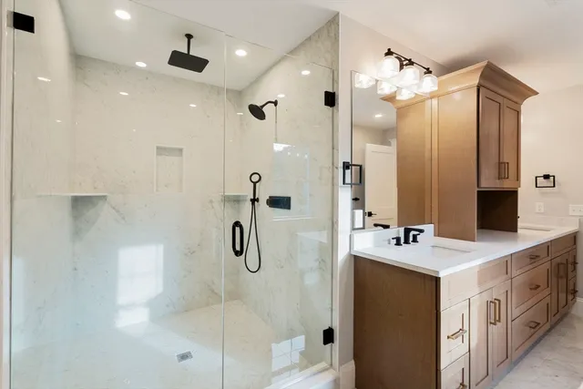 a bathroom with a double vanity sink a mirror a shower and a glass door