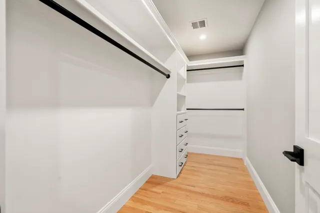 a view of walk in closet with empty racks
