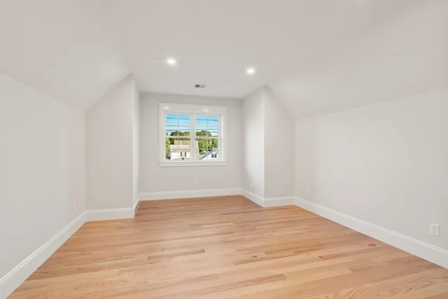 an empty room with wooden floor and window