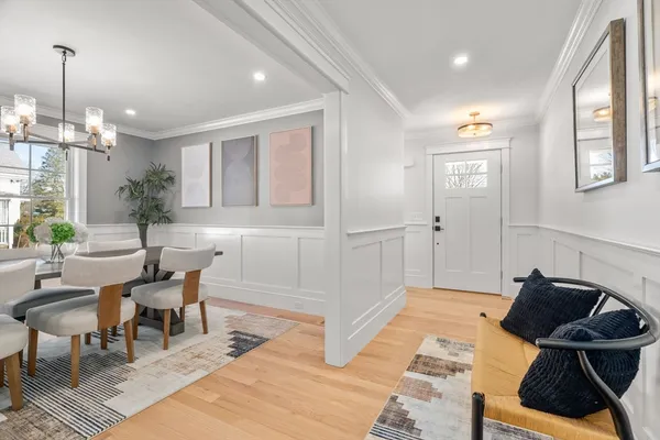 a view of a dining room and livingroom with furniture wooden floor a chandelier