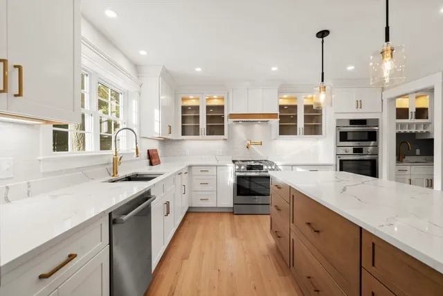 a large kitchen with stainless steel appliances granite countertop a sink stove and refrigerator