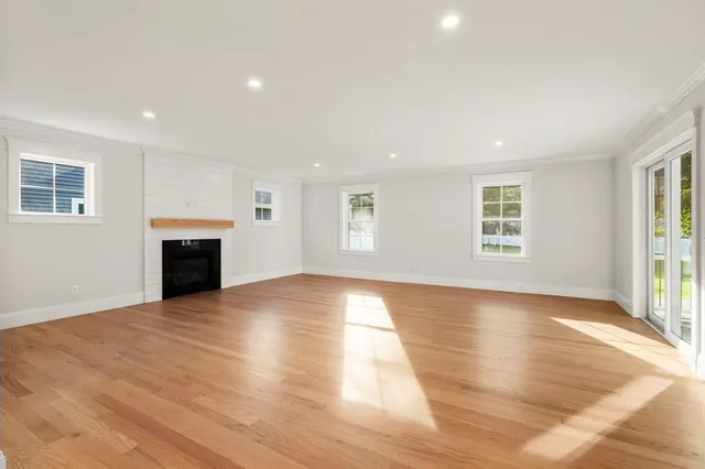 an empty room with wooden floor and fireplace