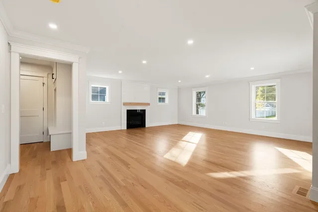 a view of empty room with wooden floor and fireplace