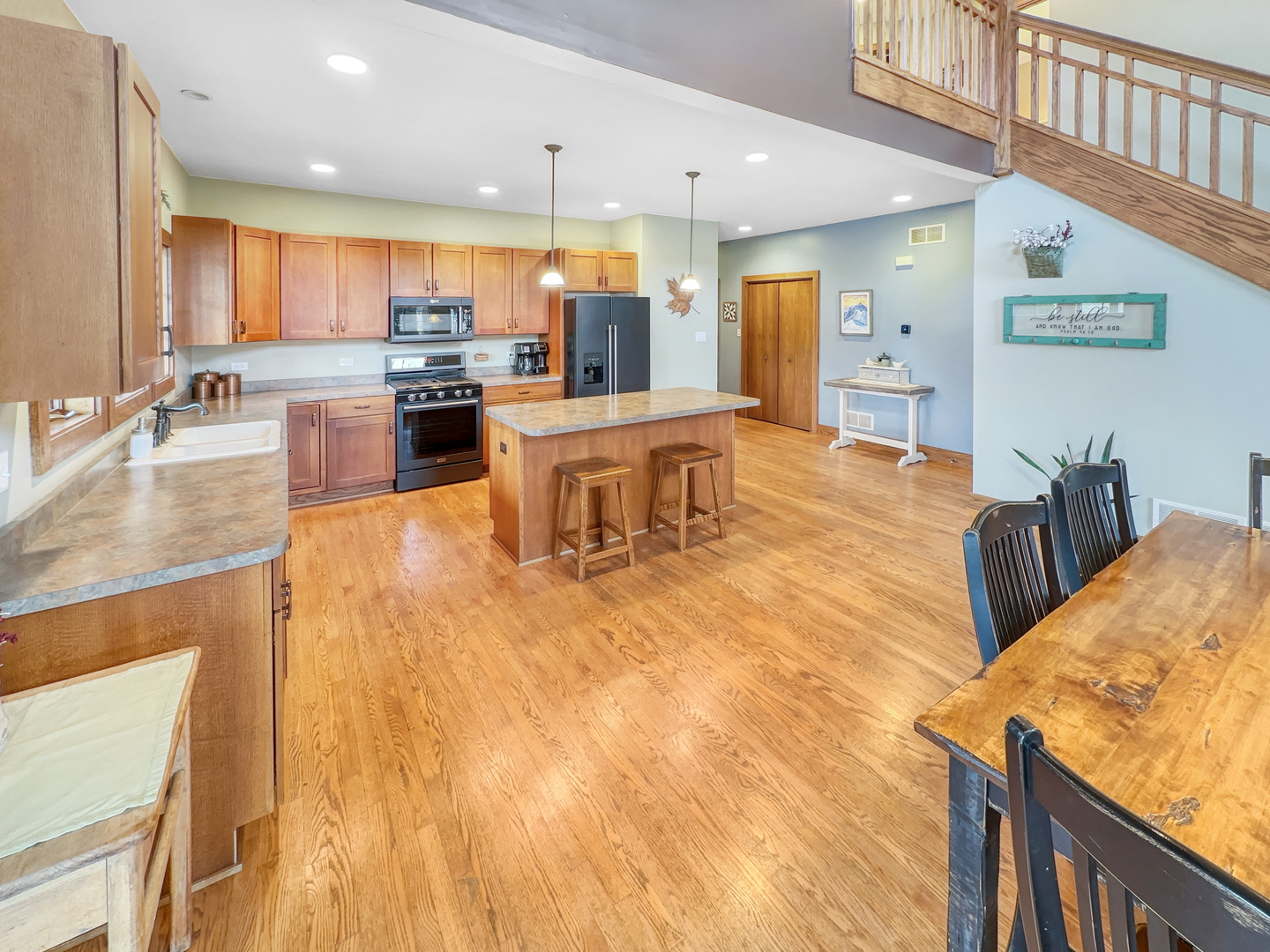493 Aberdeen Drive Crete, IL 60417 - Photo 13 of 52 a dining hall with stainless steel appliances kitchen island granite countertop a refrigerator a stove a sink and a dining table with wooden floor
