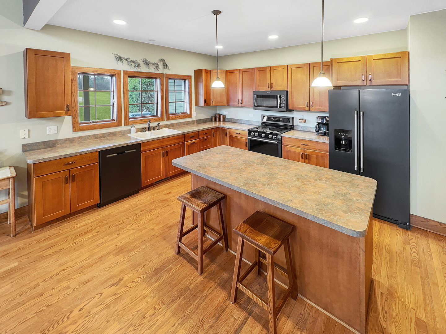 493 Aberdeen Drive Crete, IL 60417 - Photo 15 of 52 a kitchen with stainless steel appliances kitchen island granite countertop a refrigerator a stove top oven a sink dishwasher and white cabinets with wooden floor