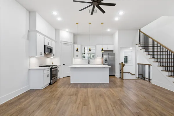 a large kitchen with kitchen island a sink stainless steel appliances and cabinets
