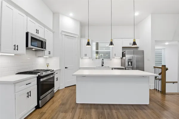 an empty room with wooden floor and ceiling fan