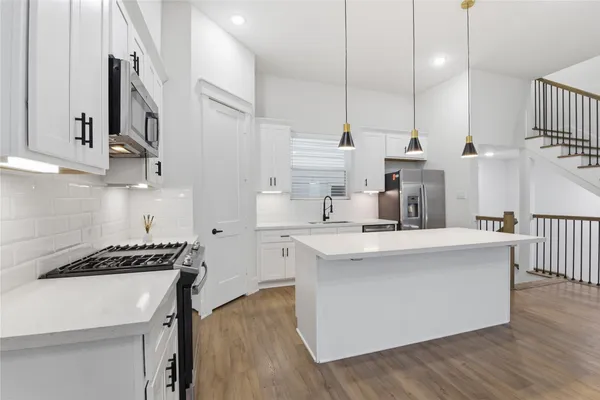 a bathroom with a double vanity sink large mirror bathtub and toilet