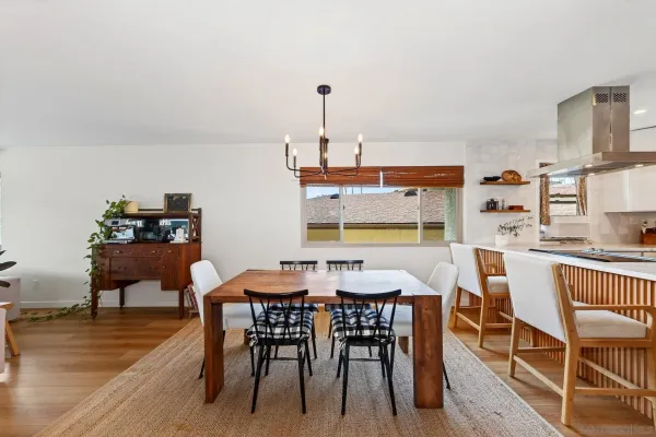 a dining room with furniture a chandelier and wooden floor