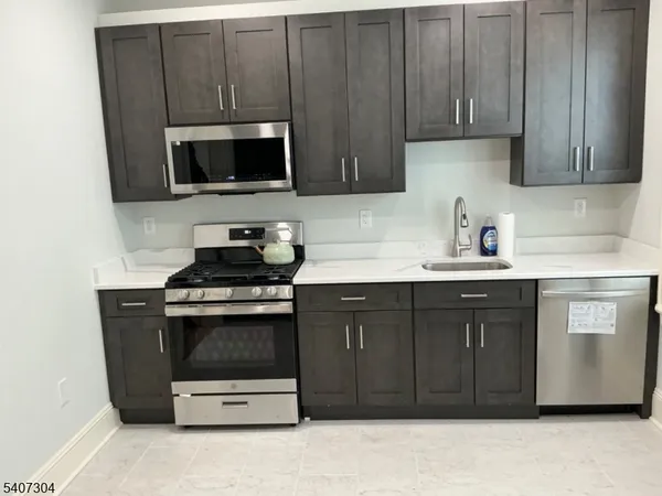a kitchen with stainless steel appliances granite countertop a stove and a microwave