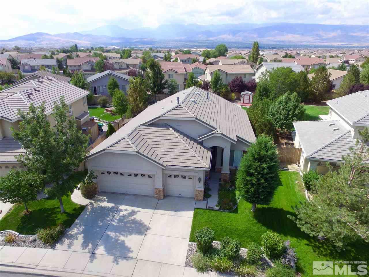 an aerial view of a house with a yard and mountain view in back