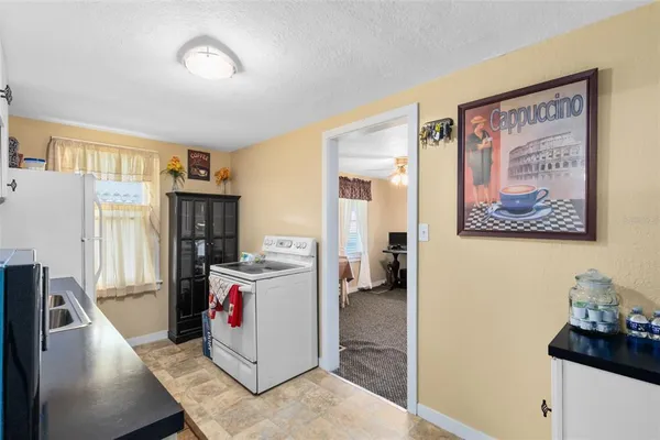 a view of a kitchen with fridge and workspace