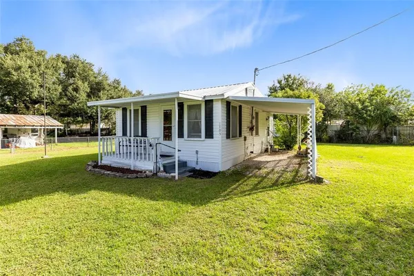 a view of a house with backyard porch and sitting area