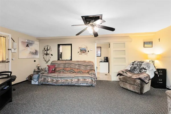 a spacious bedroom with two bed and a ceiling fan