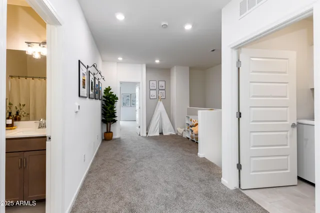 a view of hallway with furniture and a refrigerator