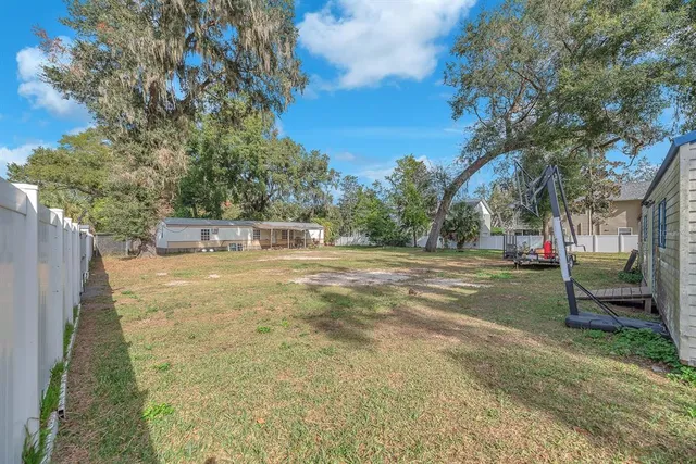 a view of backyard of house with green space