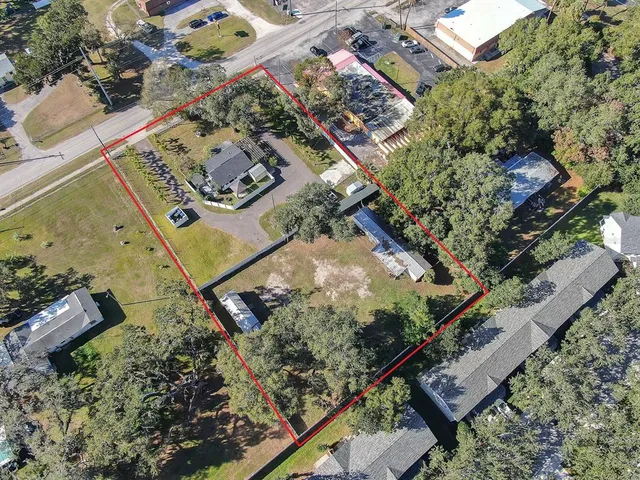 an aerial view of a house a yard and mountain
